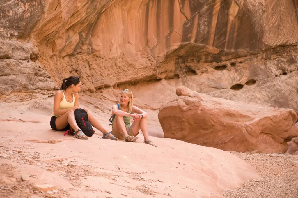 Two women resting on a rock while hiking in Red Lake Reservation