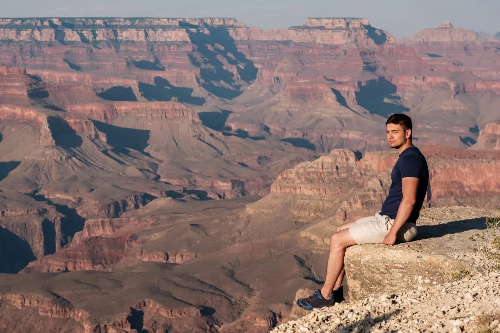 Man sitting over the ledge in the Grand Canyon