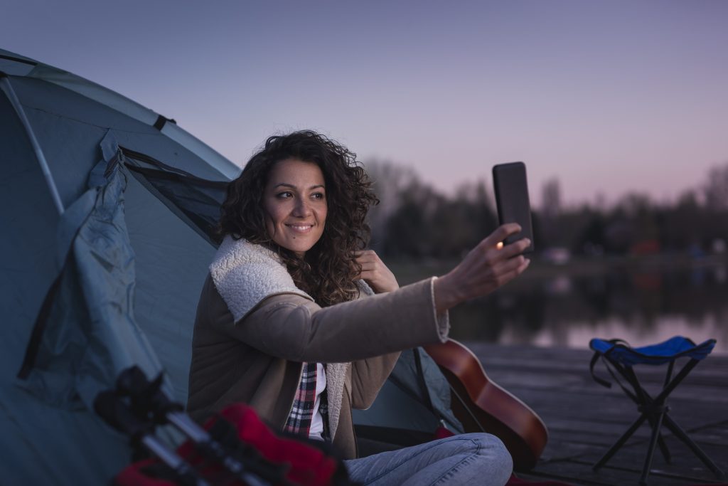 Woman taking a selfie in tent at night.