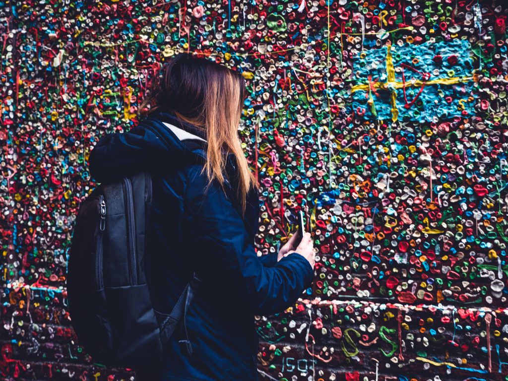 Woman taking a photo of the Chewing Gum Wall in Seattle