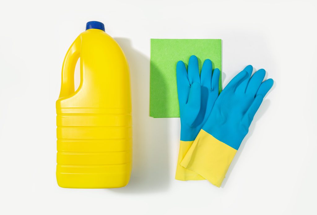 Bottle of bleach and rubber gloves flat lay product shot