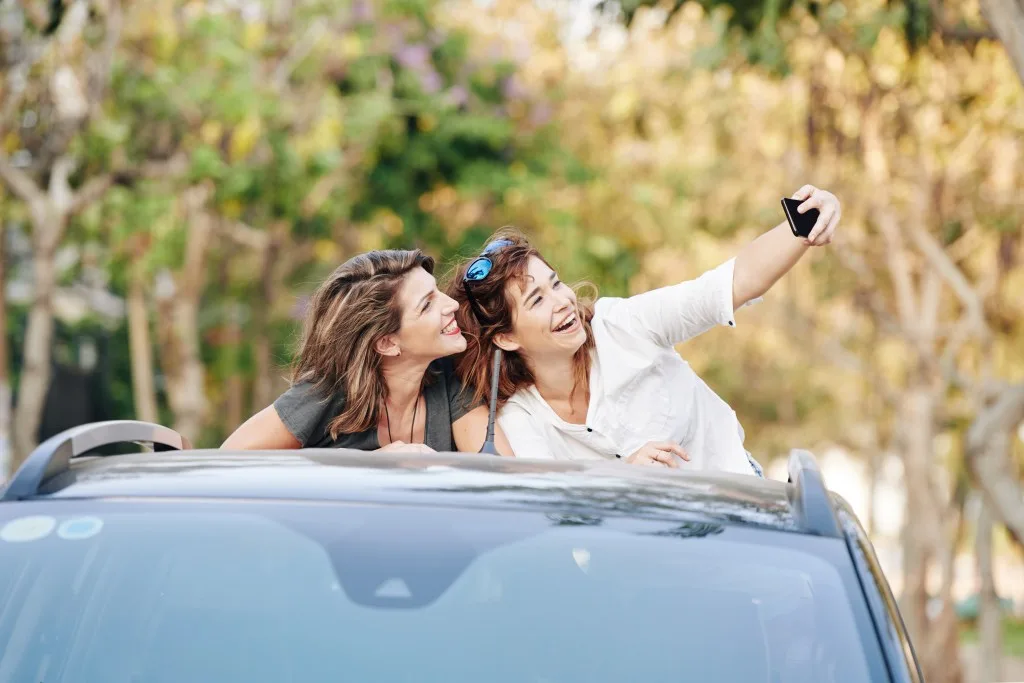 Two women taking a selfie while standing in a truck bed