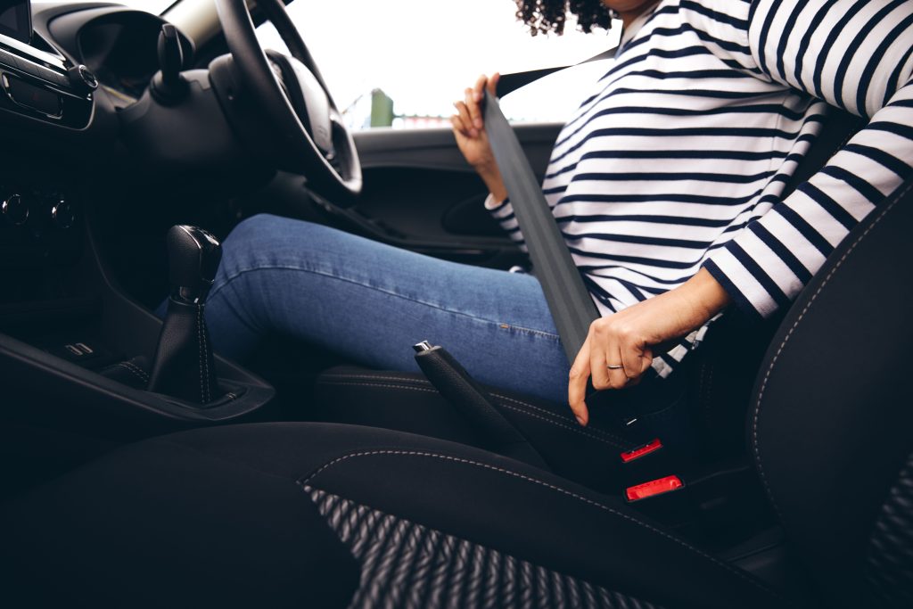 Woman putting on seatbelt before driving