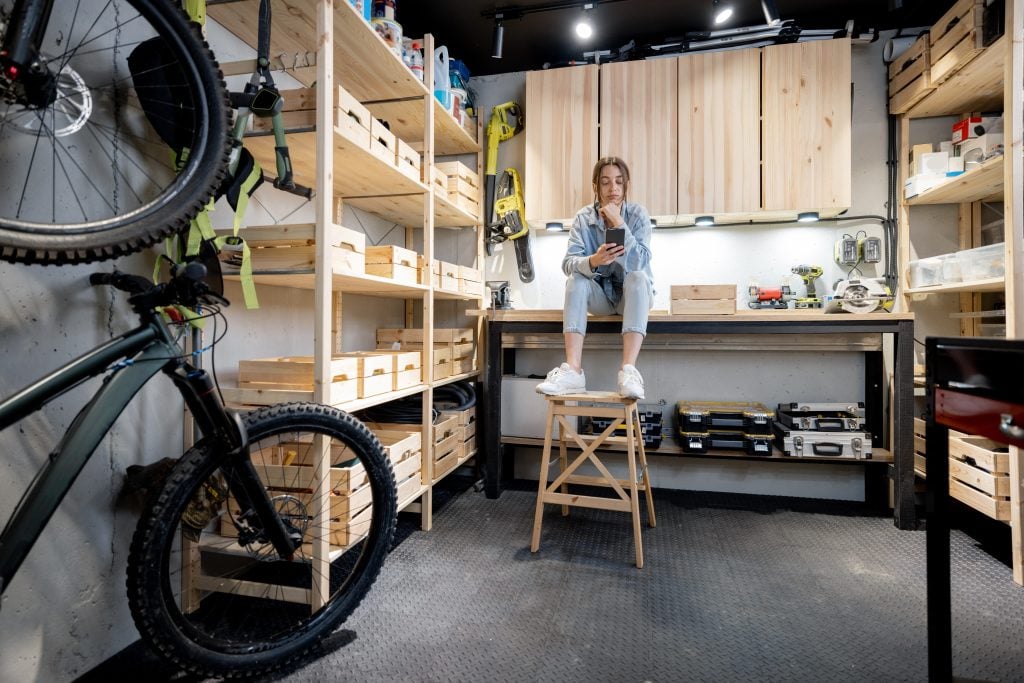 Woman sitting in organized home garage