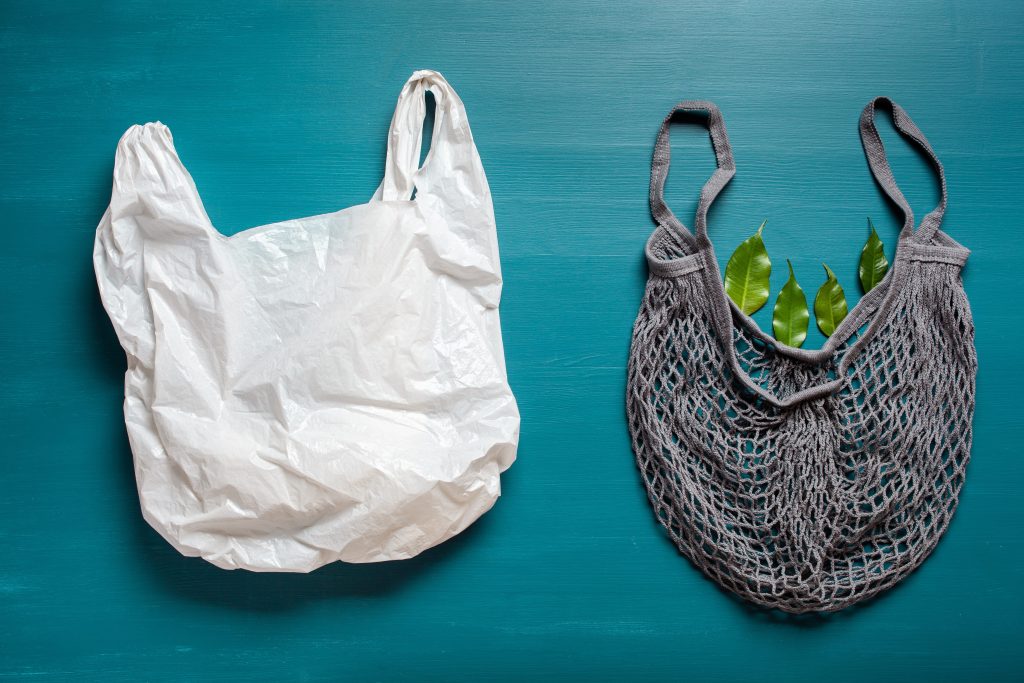 Plastic bag next to reusable bag.