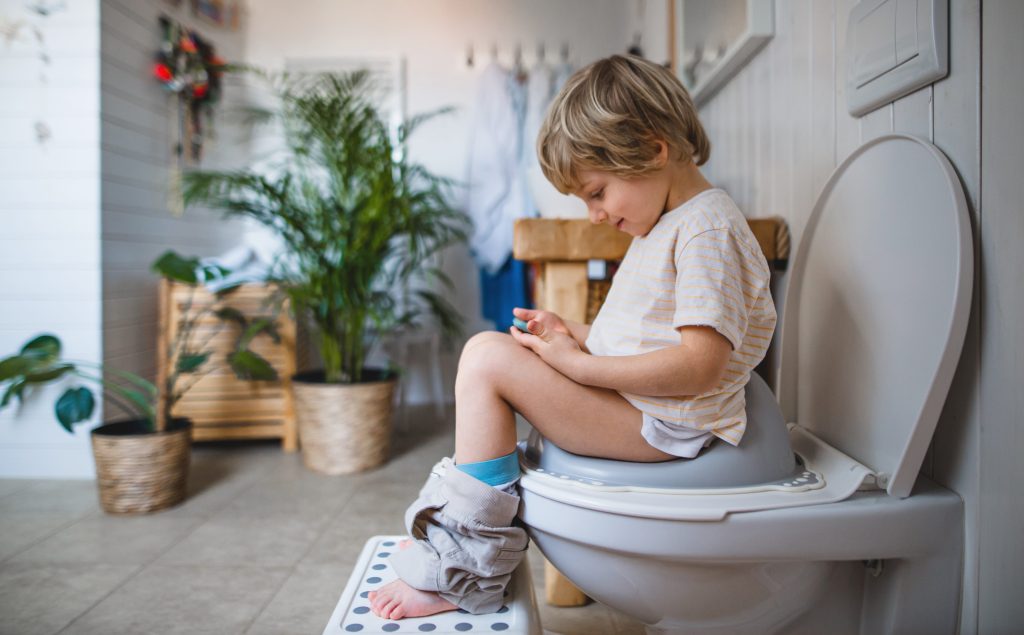 Little boy sitting on toilet