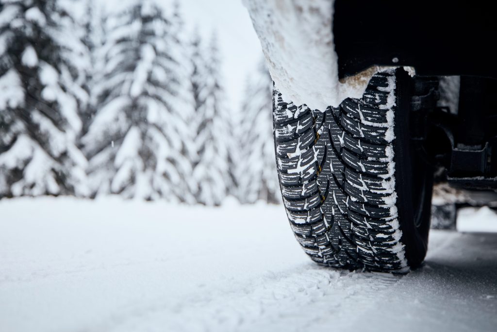 Close-up view of RV tire of in snow covered and icy road. 
