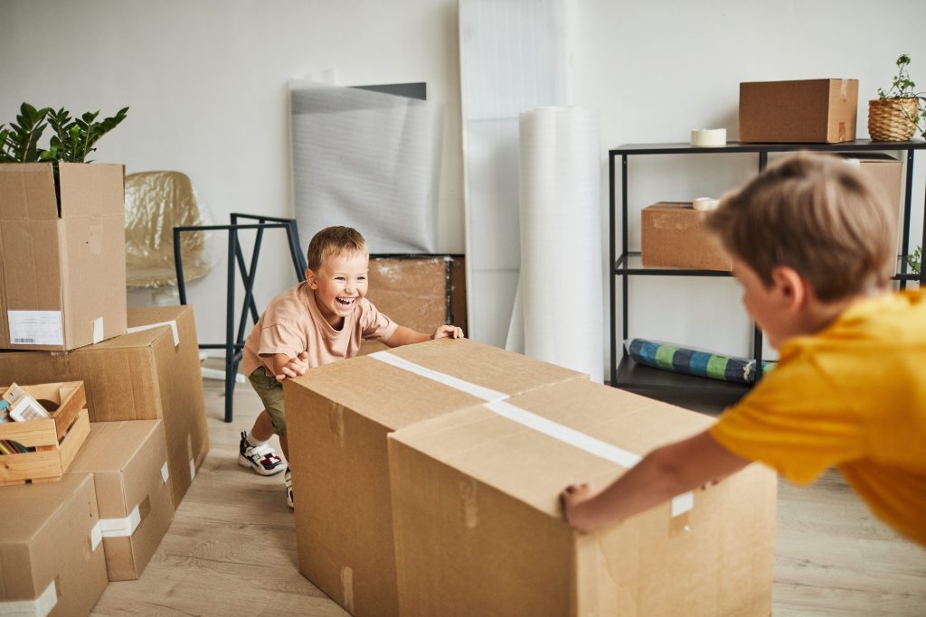 Two little boys helping move moving boxes