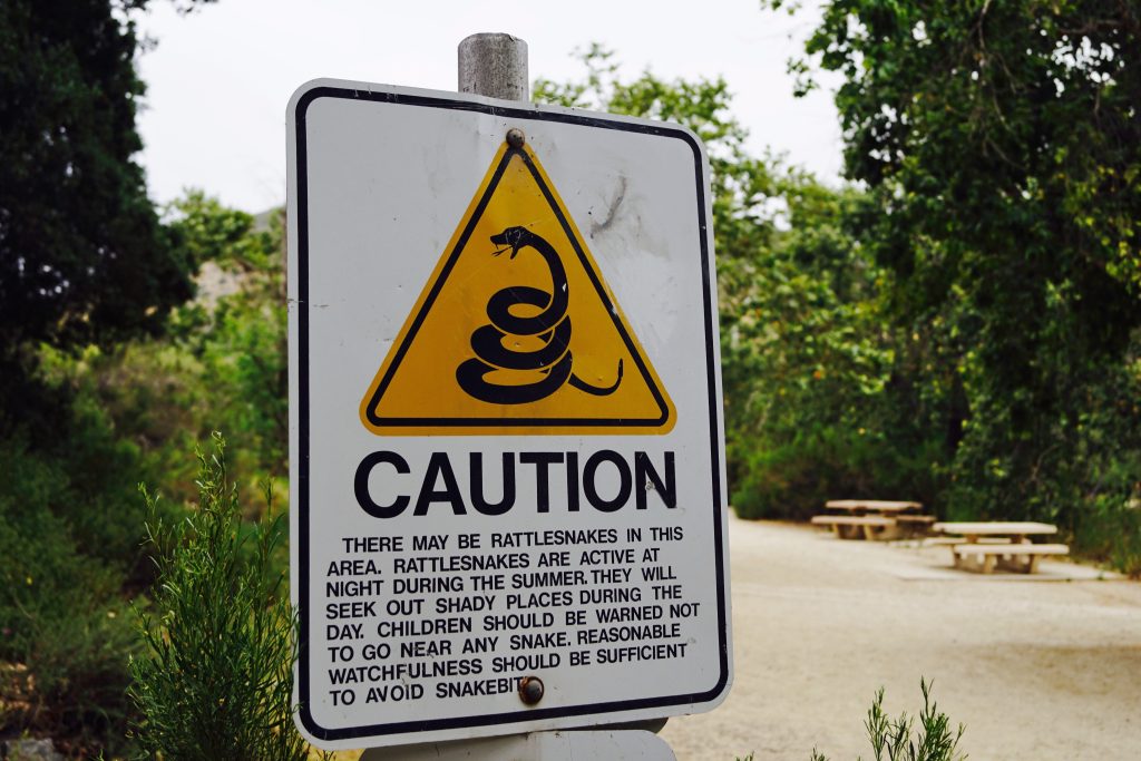 Rattlesnake caution sign on hiking trail