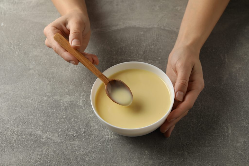 Person spooning out condensed milk