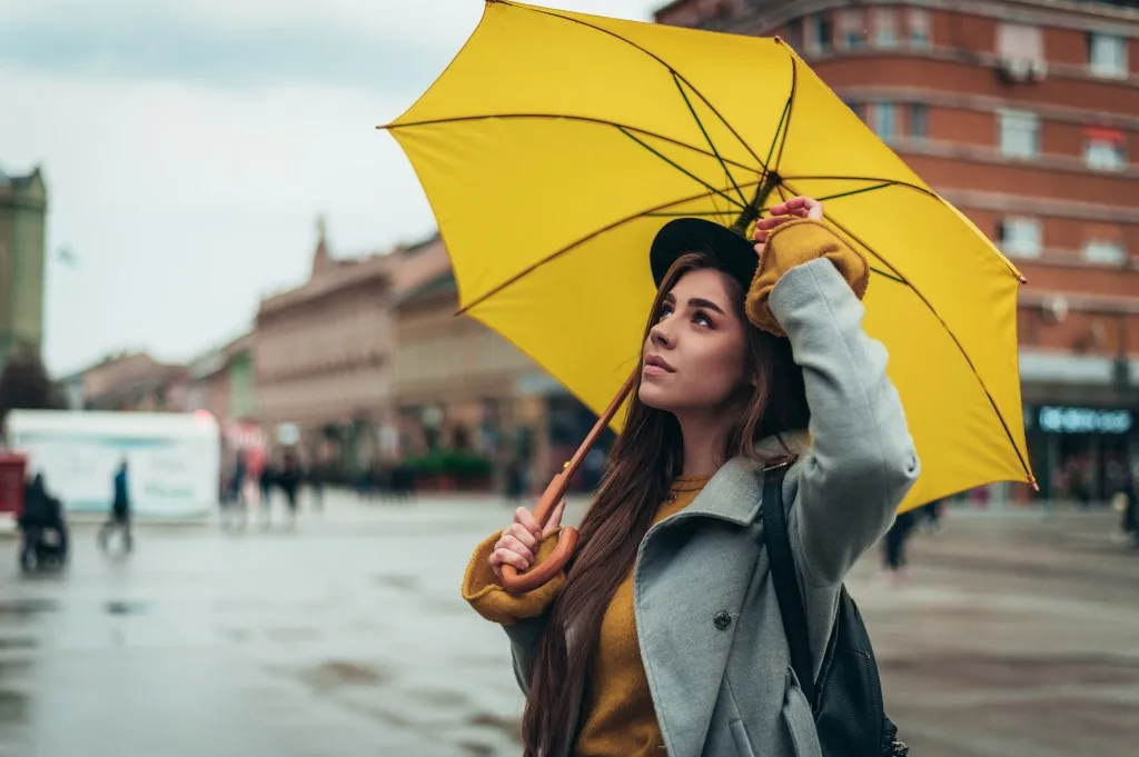 Woman walking through downtown Boise in the rain with a yellow umbrella