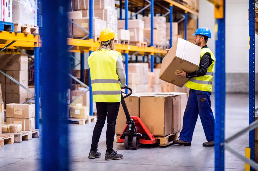 Amazon RV workers in warehouse loading or unloading a pallet truck.
