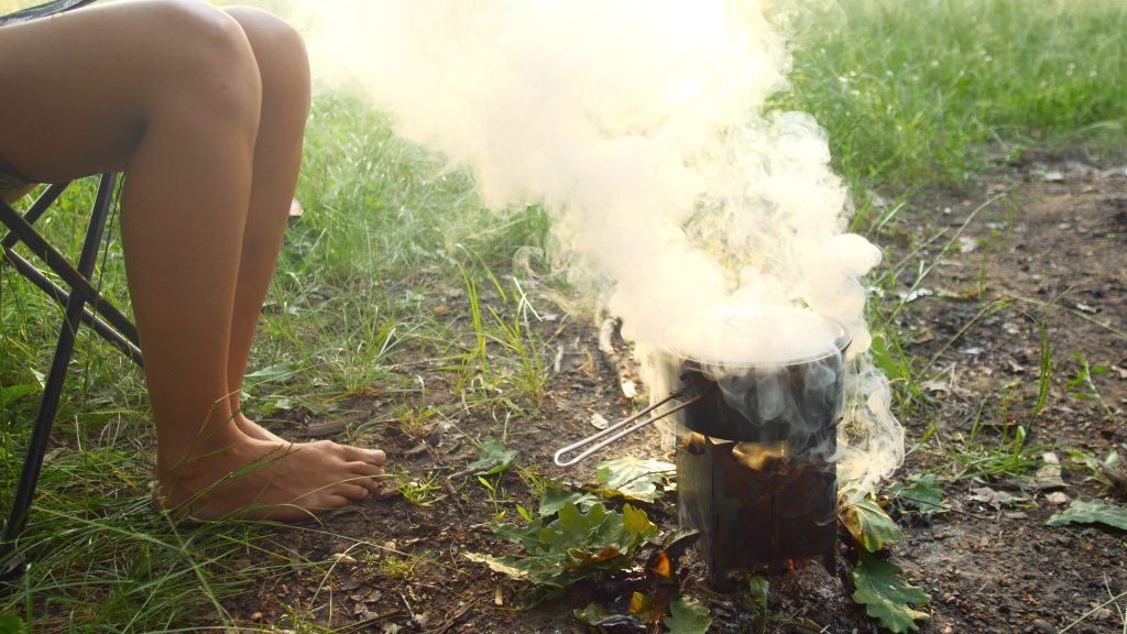 Person cooking with a hobo stove