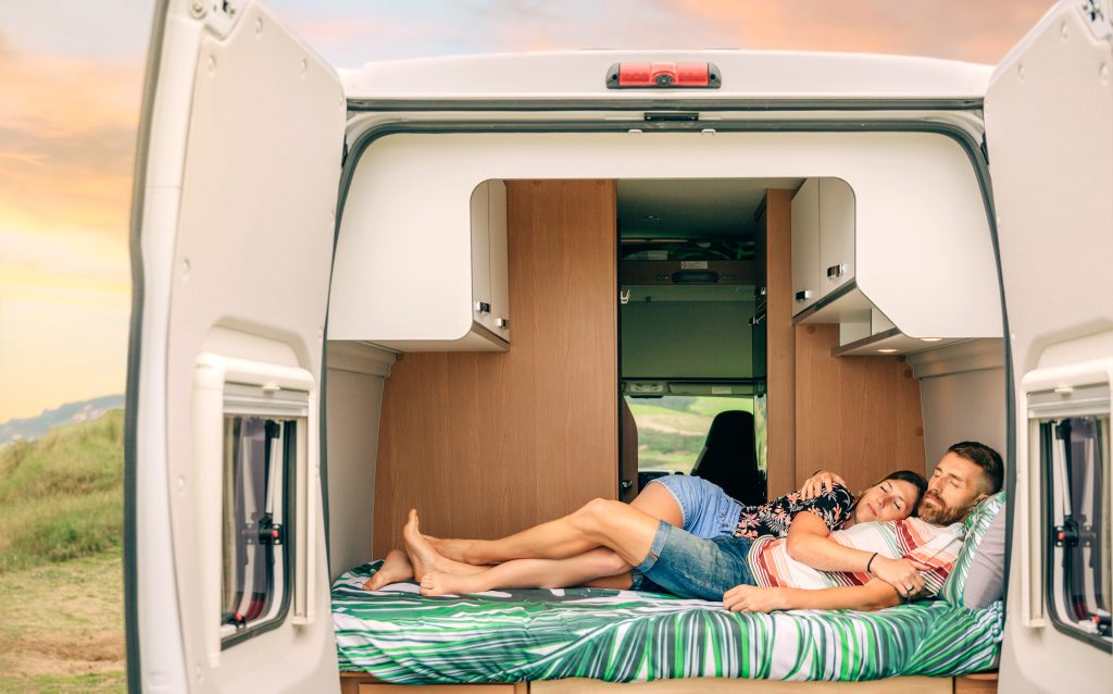 Couple sleeping in camper van while stealth camping