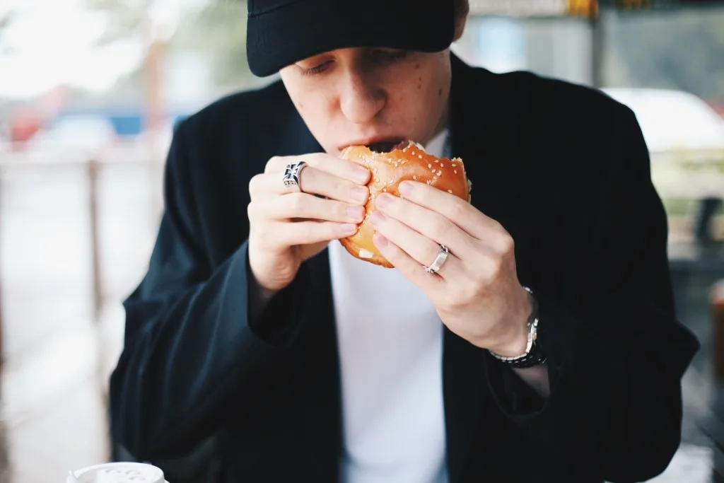 Man eating Five Guys burger