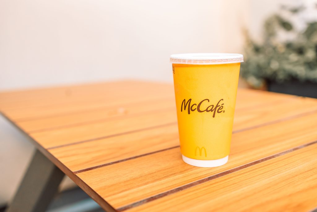 Empty McCafe cup from famous fast food chains sitting on table