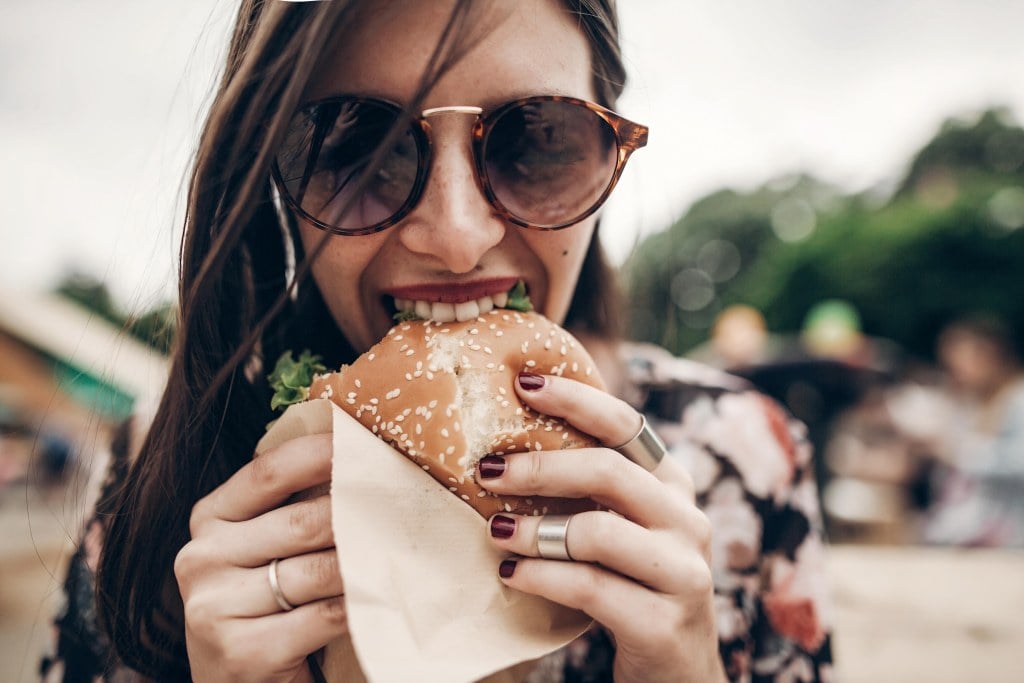 Woman taking a bite of a Five Guys burger