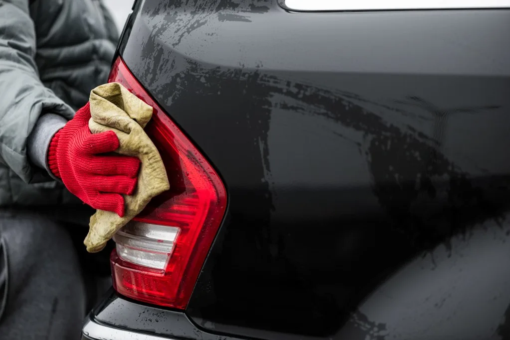 Man washing foggy headlight