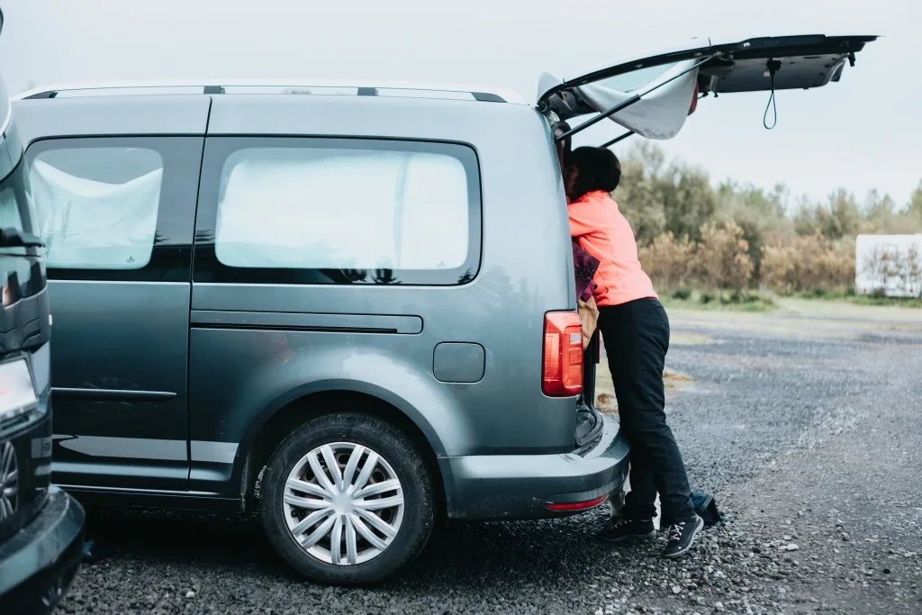 Woman packing up camper van to stealth camping
