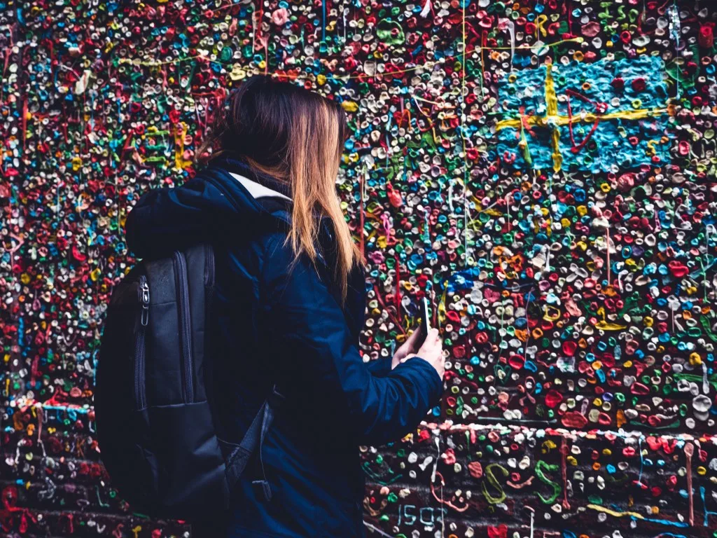 Woman putting gum on Seattle gum wall