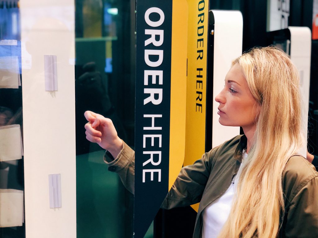 Woman ordering McDonalds breakfast at ordering station
