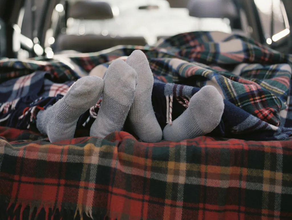 Couple laying in back of car together sleeping