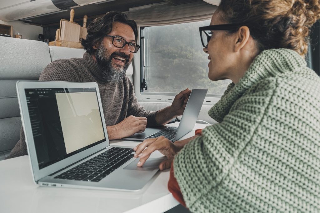 Couple working on laptops in RV