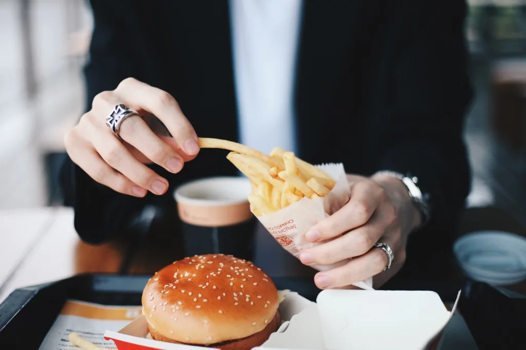 Woman eating McDonalds burger and fries