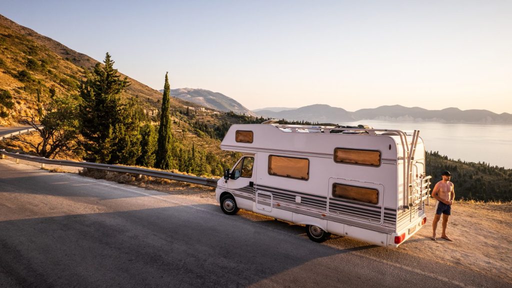Man standing next to RV at scenic view