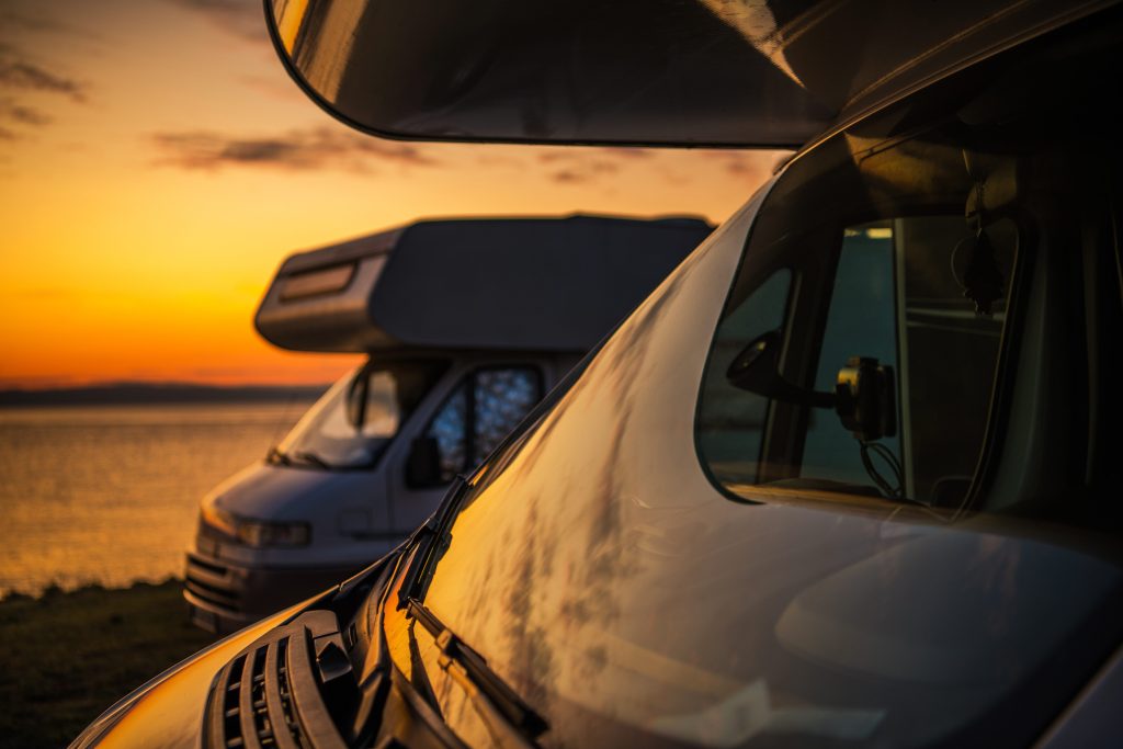 RVs parked by water at sunset