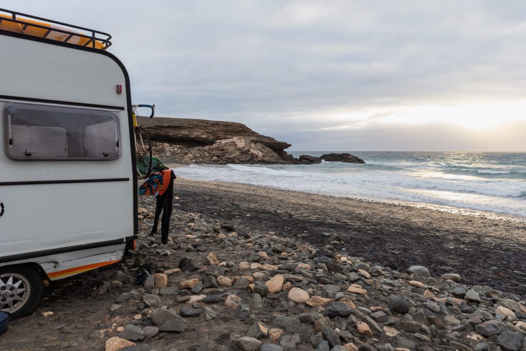 Travel trailer with trailer tires parked by the ocean