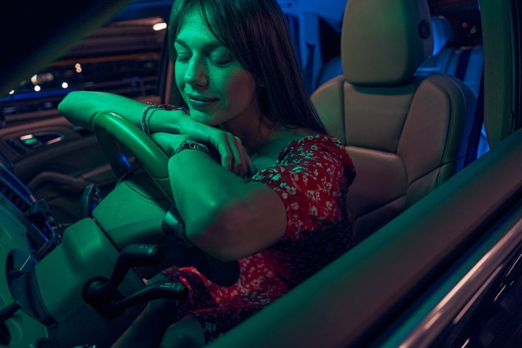 Woman sleeping on steering wheel in car