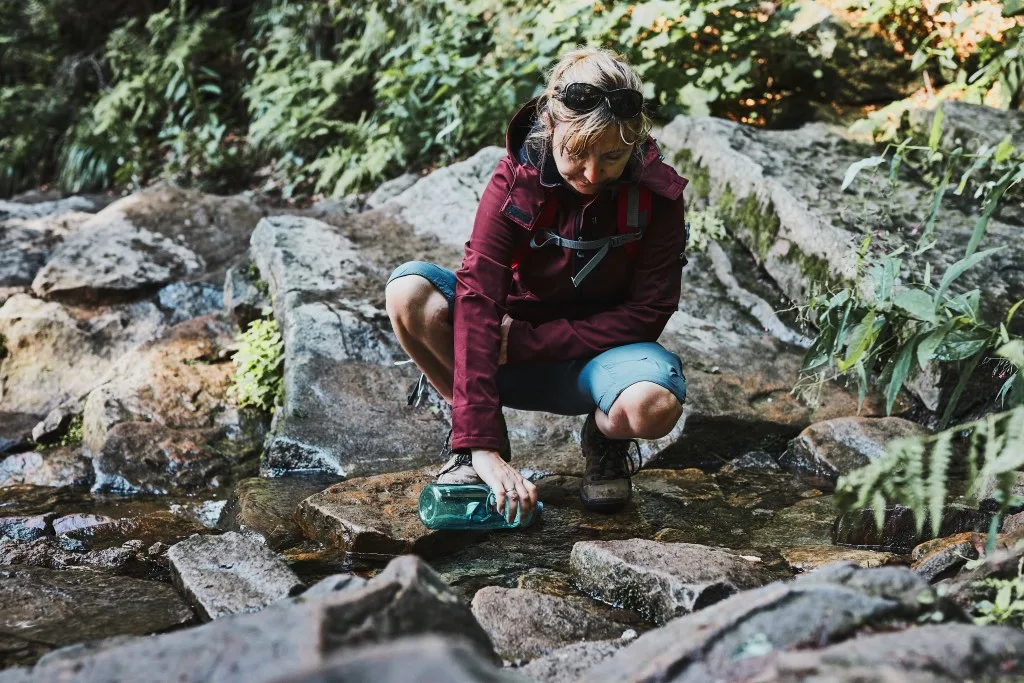 Woman getting water from stream in Yosemite