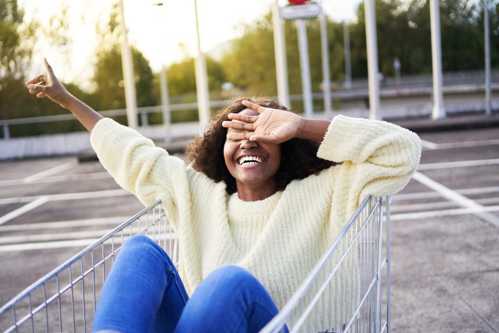 Woman smiling in grocery cart smiling in H-E-B parking lot