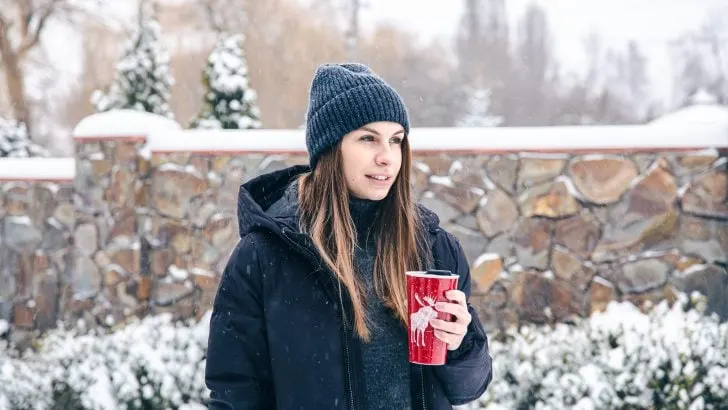 Woman drinking from a reusable Starbucks coffee cup