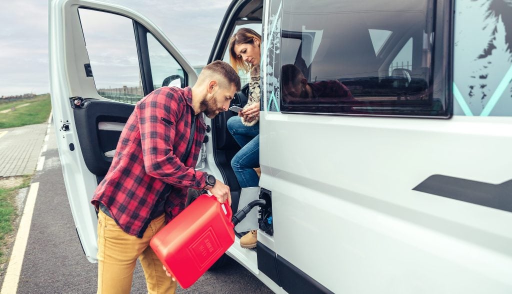 Man filling RV gas tank with canister 