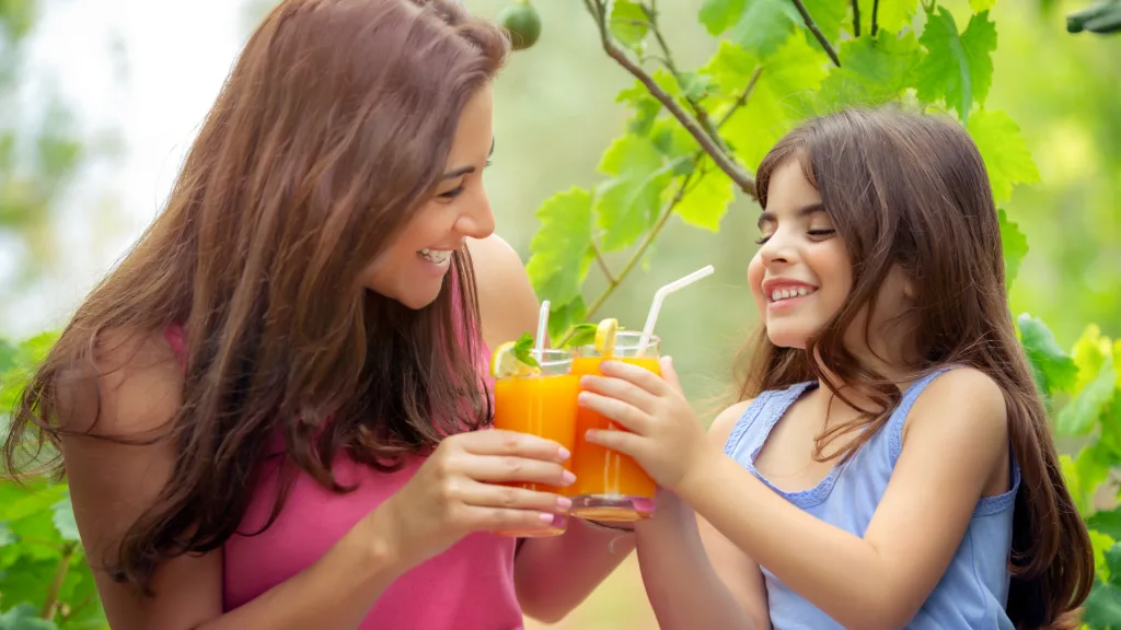 Mom and daughter drinking orange juice