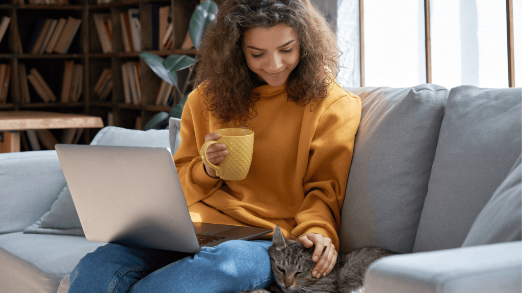 Woman working on laptop with cat