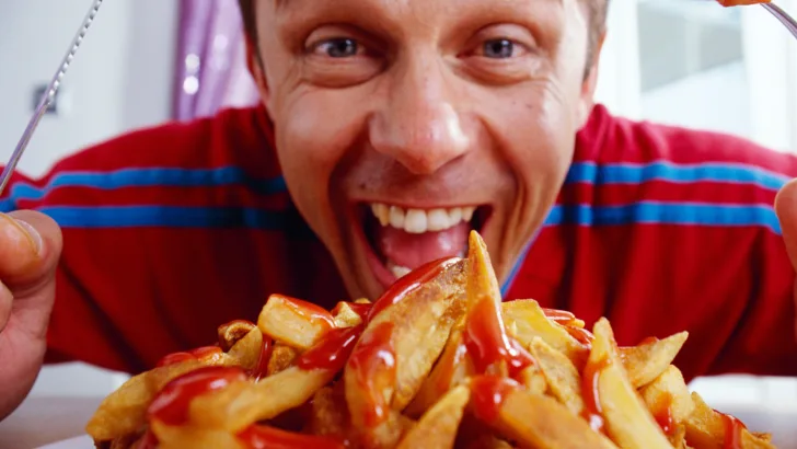 Man happily eating french fries