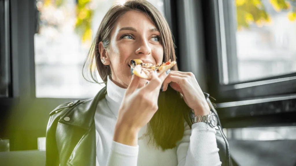 Woman eating white clam pizza