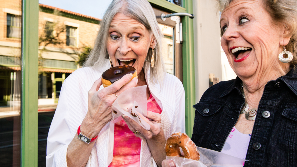 Two women eating donuts in Portland