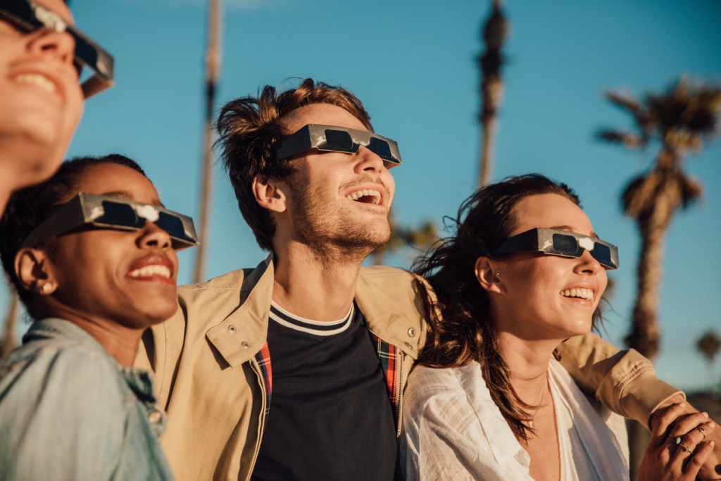 People with protective glasses watching a solar eclipse