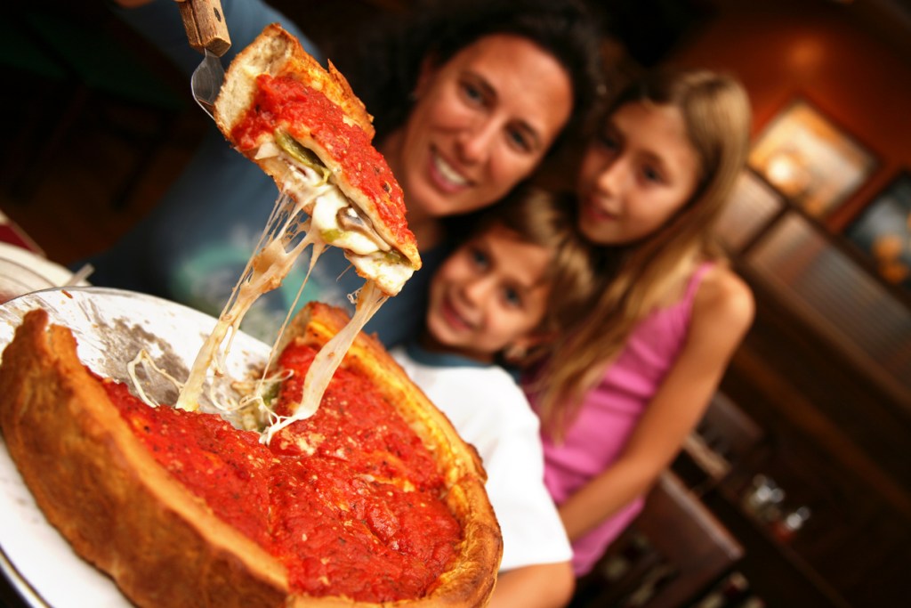 A family enjoying a deep dish Chicago Style Pizza.