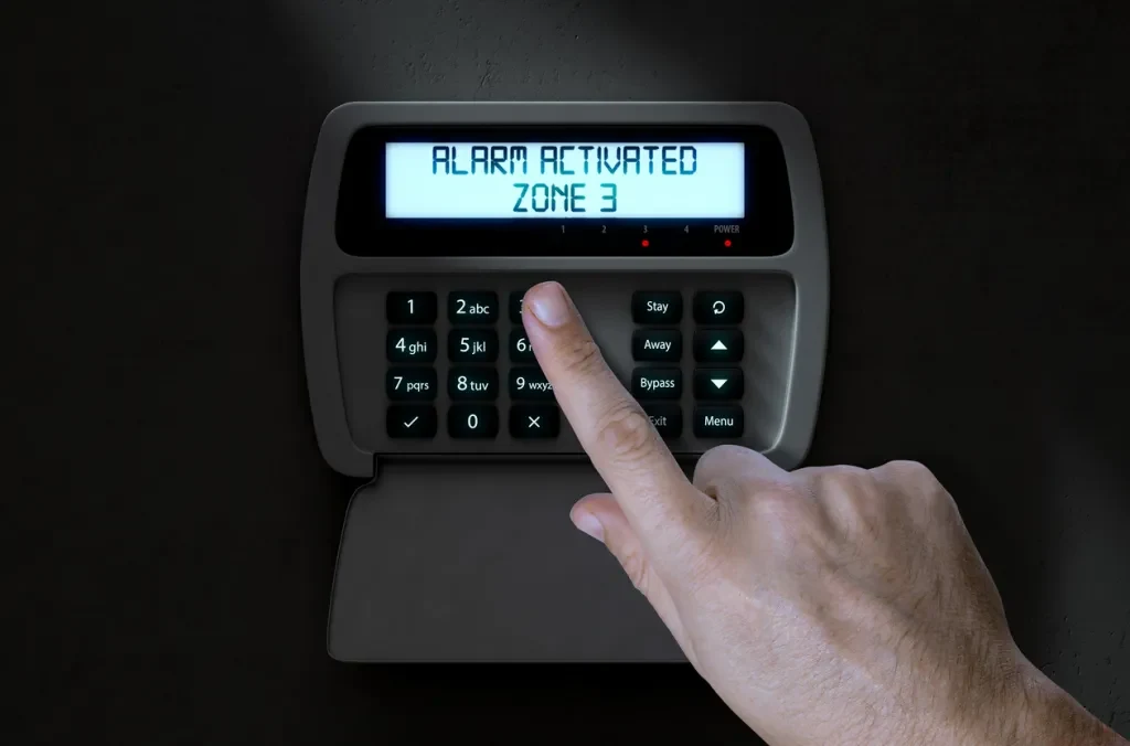 A person pushing a button on a home security alarm panel