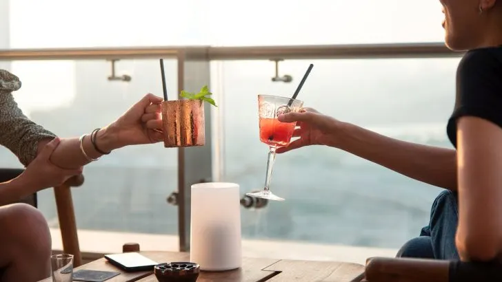 People raising their glasses in a toast at a rooftop bar