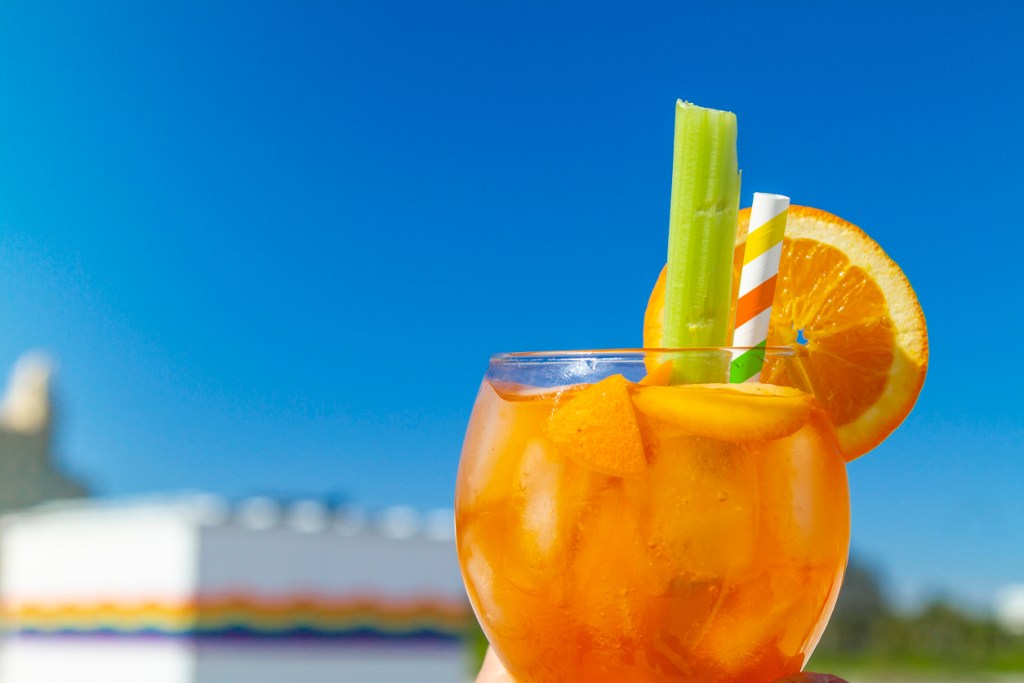 A bright orange cocktail against a blue sky. A scene similar to what you'd find on a rooftop bar in Miami