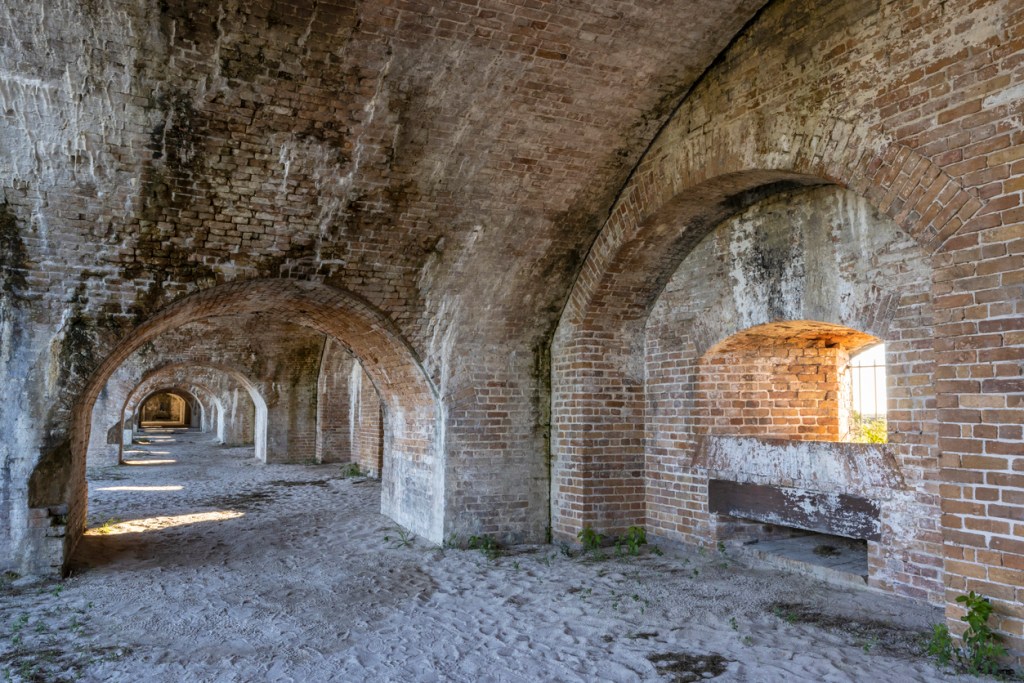 Fort Pickens is an excellent day trip from Pensacola

Limestone leaks onto the brick arches and walls of an exterior casemate in historic Fort Pickens in Gulf Islands National Seashore near Pensacola Beach, Florida.