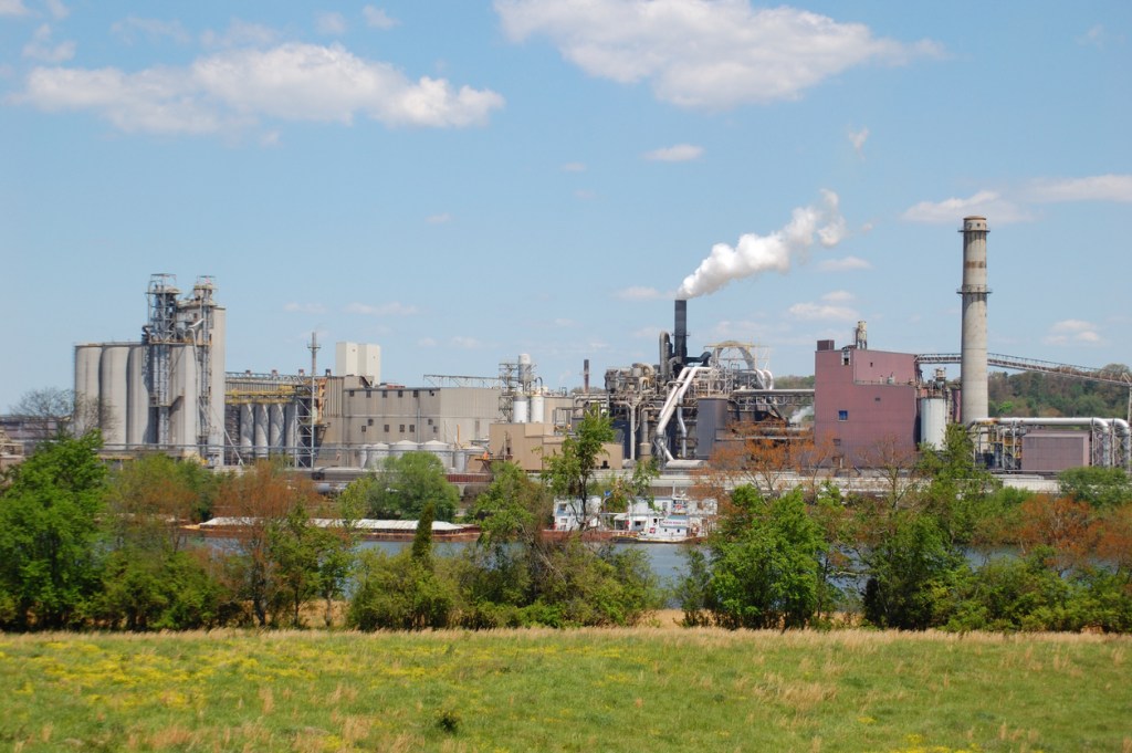 A manufacturing facility or factory on the river. Many people blame industrial plants for polluting the Ohio River. 