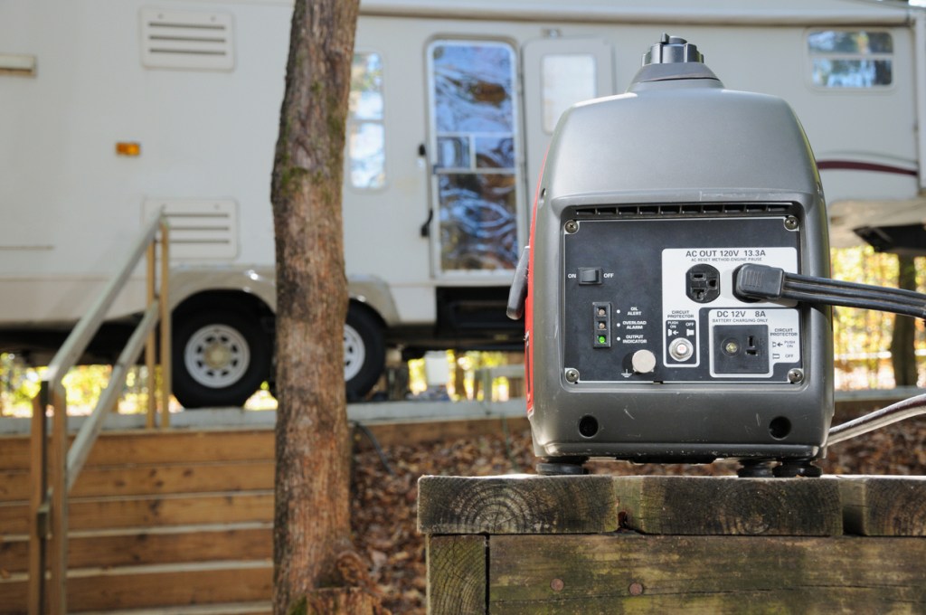 Close up of portable gasoline inverter generator providing power for fifth wheel rv trailer in campground