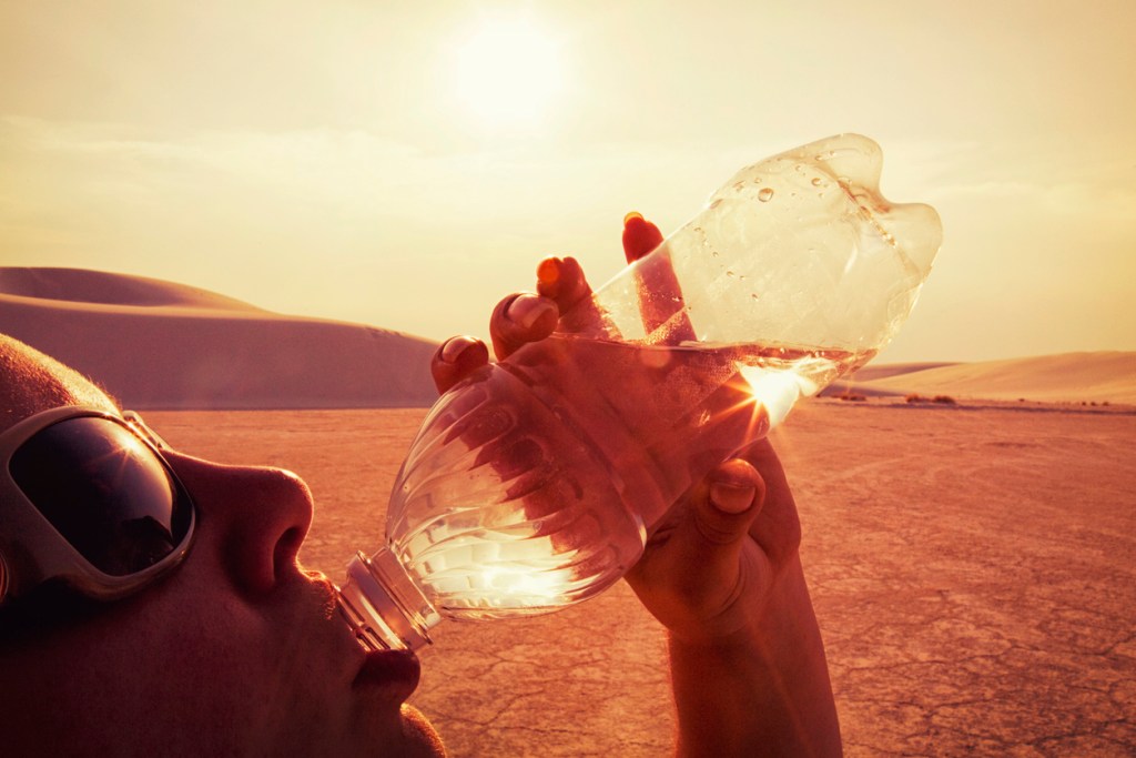 Woman drinking water in the desert. Dehydration is one of the dangers at White Sands National Park.